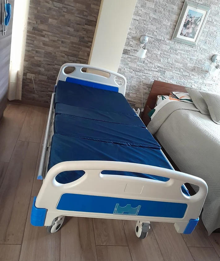Cama hospitalaria eléctrica con barandas y colchón azul